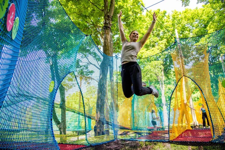 Une participante saute dans les grands filets colorés d’uplå au Mont-Saint-Grégoire