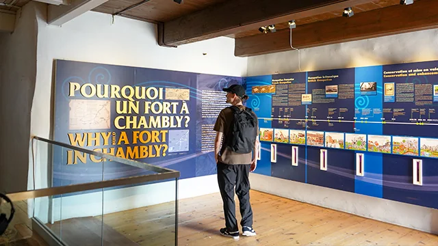 Un visiteur consulte une exposition historique à l’intérieur du fort Chambly