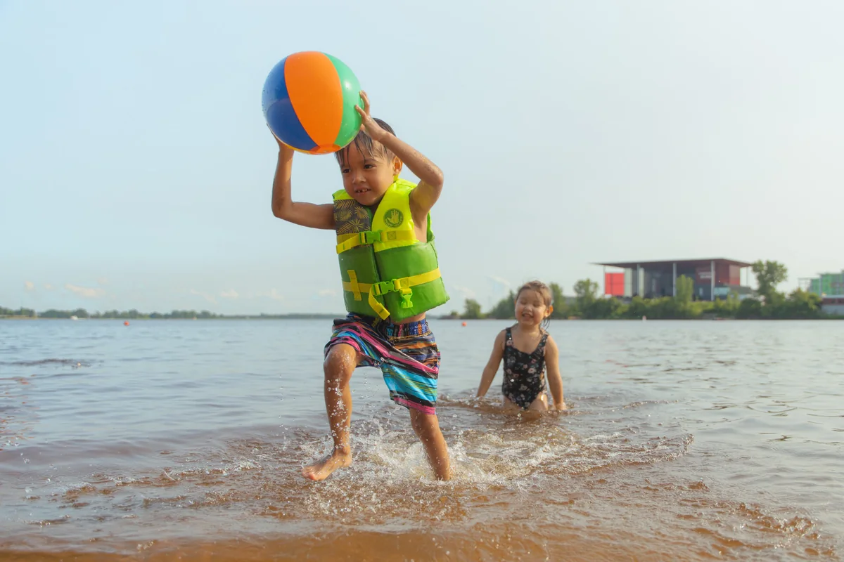 Deux jeunes enfants jouent dans l’eau à la plage de l’île Saint-Quentin