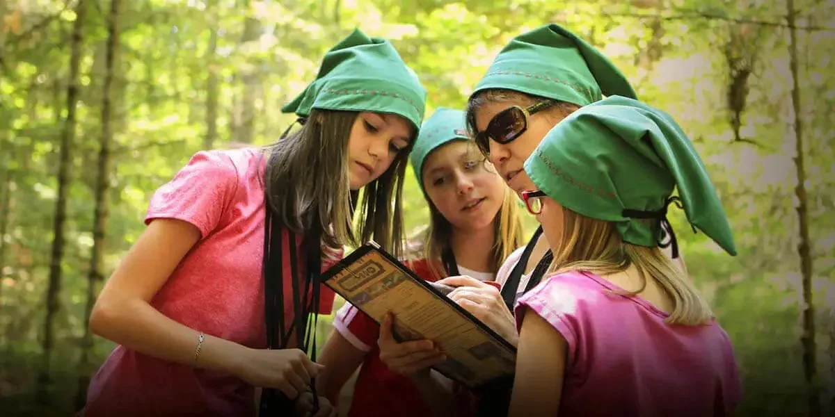 Famille en chapeaux de gnomes consultant une carte dans la forêt