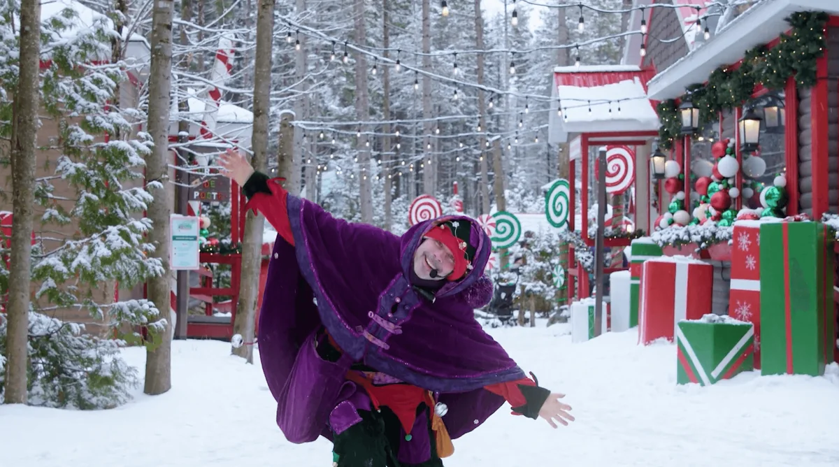 Personnage costumé dans le village de Noël enneigé de Frima